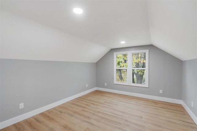 additional living space featuring lofted ceiling and light wood-type flooring