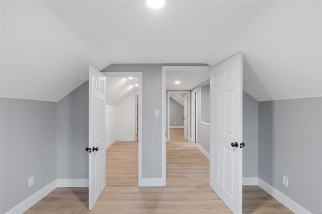 additional living space featuring lofted ceiling and light hardwood / wood-style flooring