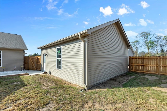 view of side of property with a yard and a patio