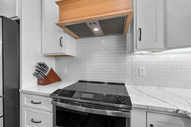 kitchen featuring tasteful backsplash, stainless steel appliances, white cabinets, light stone counters, and exhaust hood