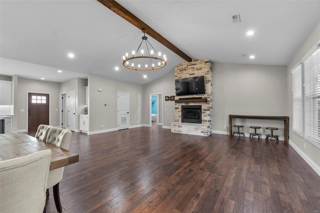 living room featuring dark wood-type flooring, vaulted ceiling with beams, a fireplace, and a chandelier