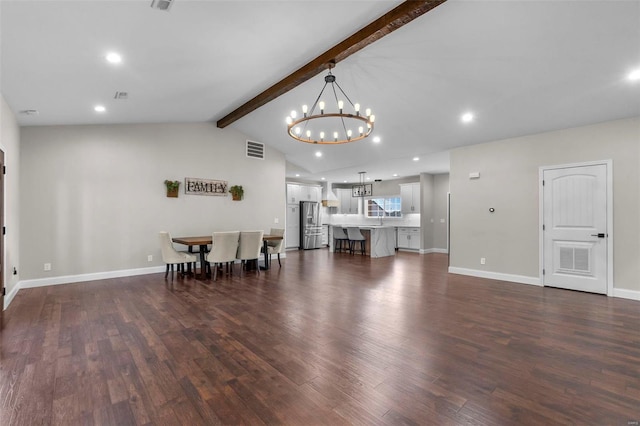 living room with lofted ceiling with beams, a chandelier, and dark hardwood / wood-style flooring