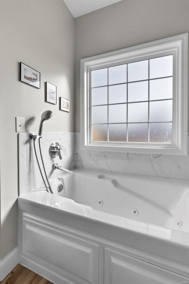 bathroom with hardwood / wood-style flooring and a washtub