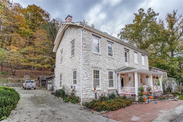 view of front facade with cooling unit, covered porch, and a garage