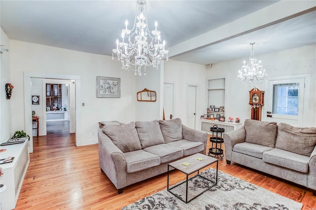 living room featuring beamed ceiling, light hardwood / wood-style flooring, and an inviting chandelier