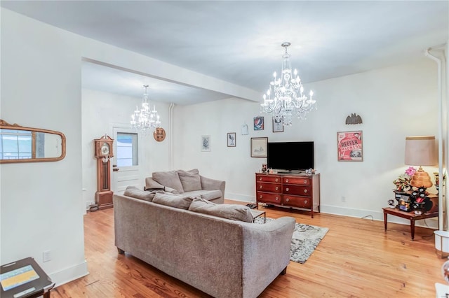 living room with an inviting chandelier and light hardwood / wood-style floors