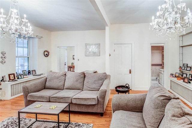 living room with light hardwood / wood-style flooring, radiator heating unit, and an inviting chandelier