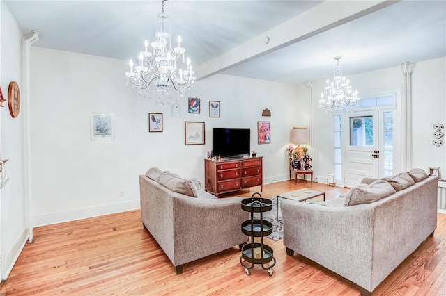 living room with beamed ceiling, a notable chandelier, and light hardwood / wood-style floors