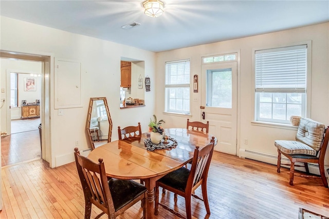 dining area with baseboard heating and light wood-type flooring