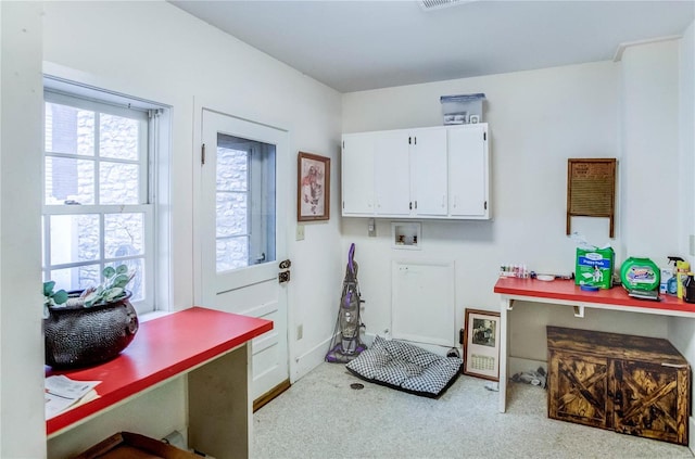 washroom with light carpet, washer hookup, and cabinets