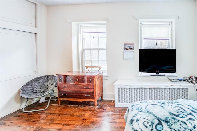 bedroom with dark wood-type flooring and radiator