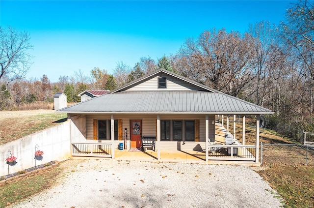 farmhouse-style home featuring a porch and a storage shed