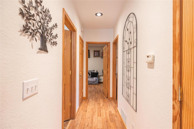 corridor with light hardwood / wood-style floors