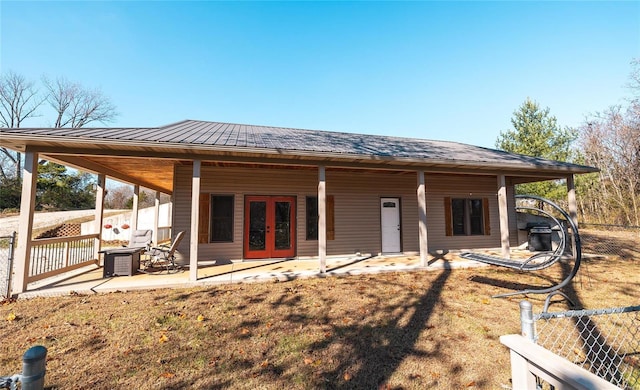 rear view of house with french doors, cooling unit, and a lawn