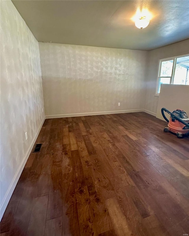 empty room with dark hardwood / wood-style flooring