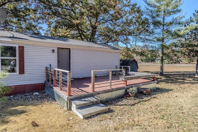 exterior space featuring a wooden deck, a yard, and a storage shed