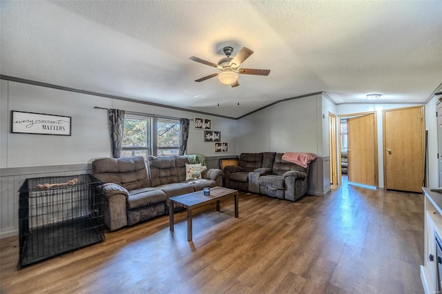 living room with a textured ceiling, crown molding, and wood-type flooring