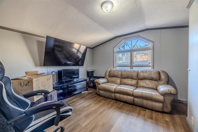 living room with crown molding, a textured ceiling, hardwood / wood-style flooring, and vaulted ceiling