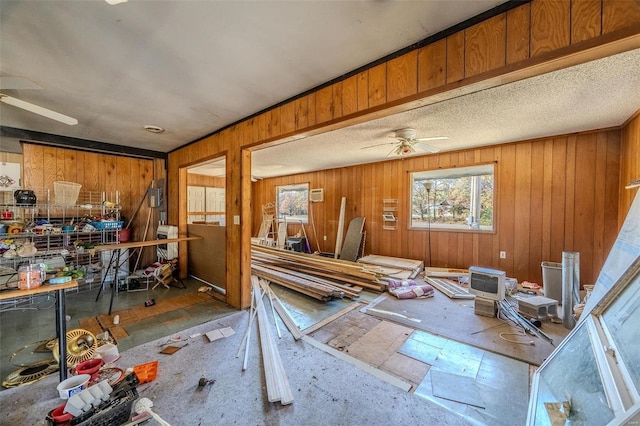 misc room with ceiling fan and wooden walls