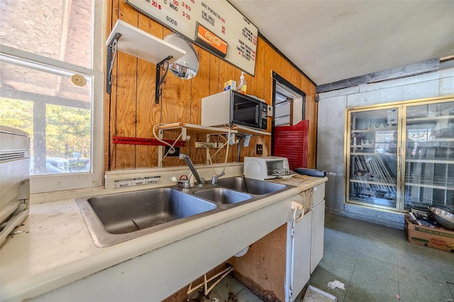 kitchen featuring wood walls and sink