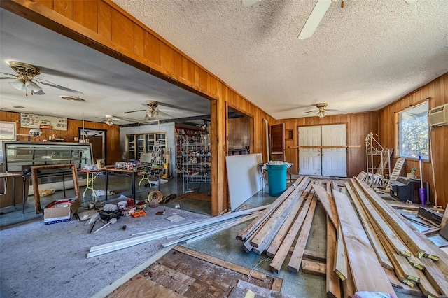 miscellaneous room featuring wooden walls and a textured ceiling