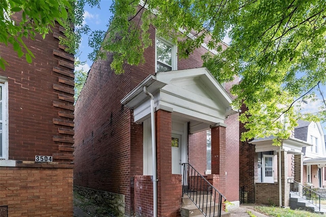 view of front facade featuring brick siding and entry steps