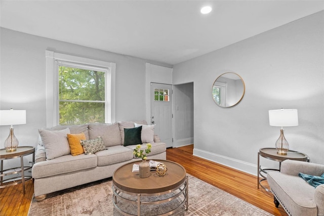 living room with recessed lighting, baseboards, and wood finished floors