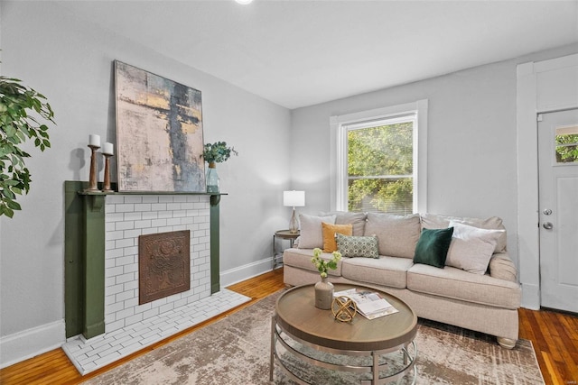 living room with a fireplace, wood finished floors, and baseboards