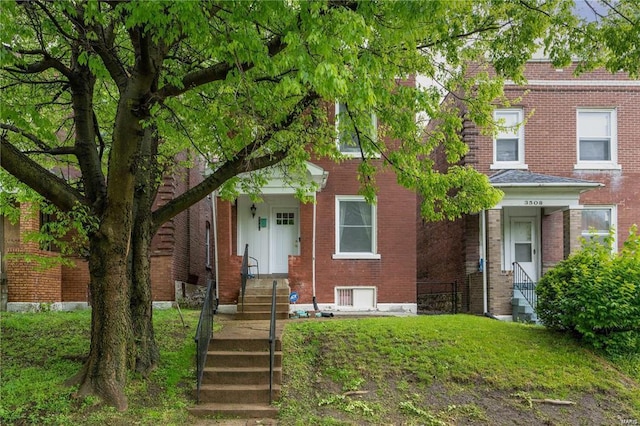 view of front of house featuring brick siding and a front lawn