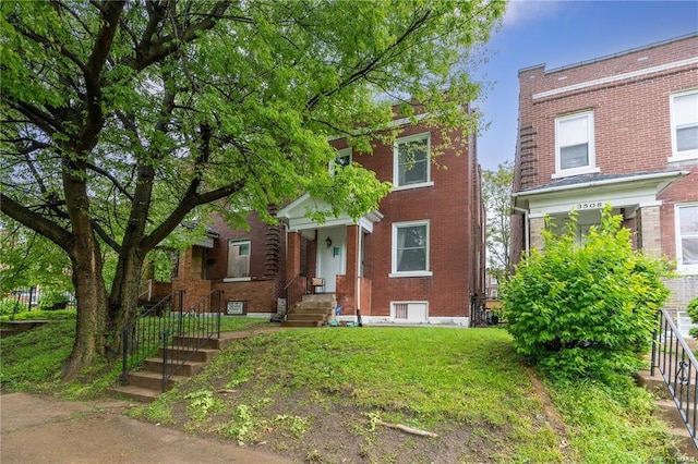 view of front of home featuring brick siding and a front lawn