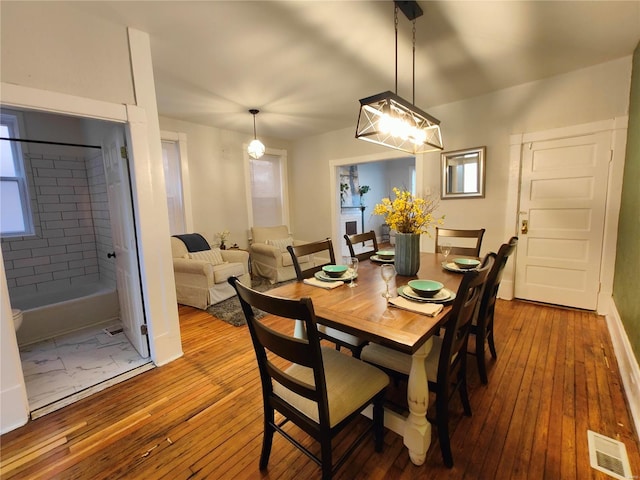 dining area featuring visible vents and wood-type flooring