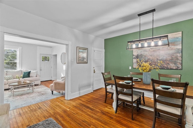 dining area with baseboards and wood-type flooring