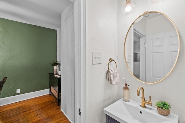 bathroom featuring baseboards, wood finished floors, and vanity