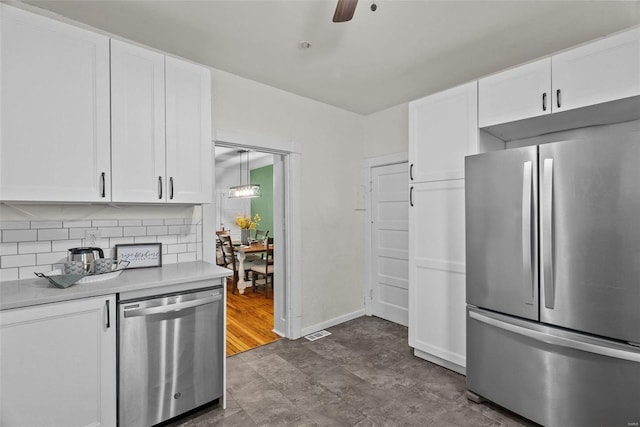 kitchen featuring a ceiling fan, light countertops, white cabinets, appliances with stainless steel finishes, and backsplash