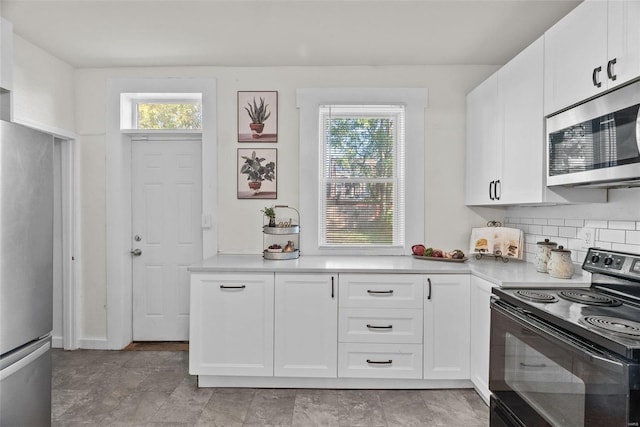 kitchen with a wealth of natural light, backsplash, appliances with stainless steel finishes, and light countertops