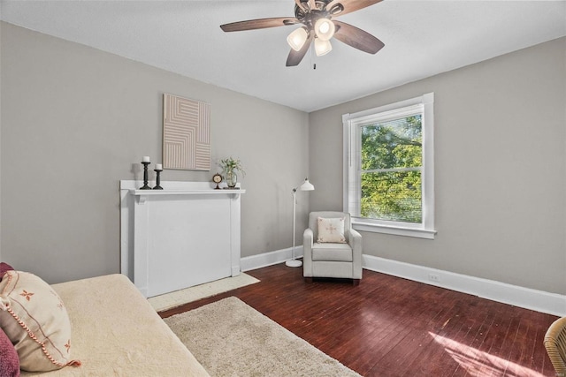 sitting room featuring baseboards, wood finished floors, and a ceiling fan