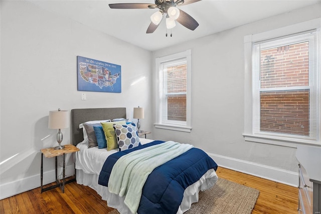 bedroom featuring ceiling fan, baseboards, and wood finished floors