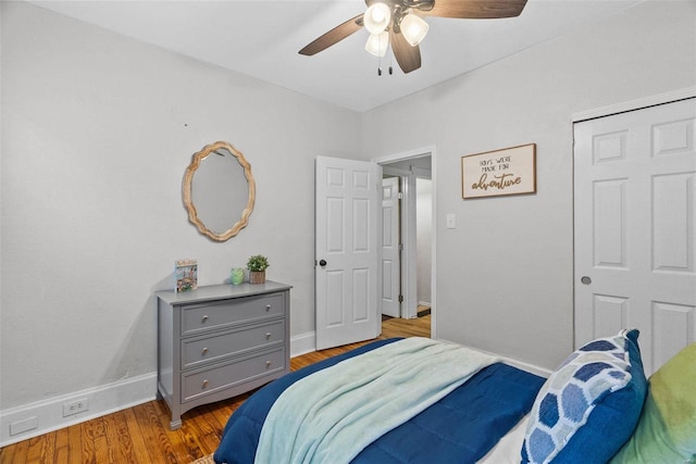 bedroom with a ceiling fan, wood finished floors, and baseboards