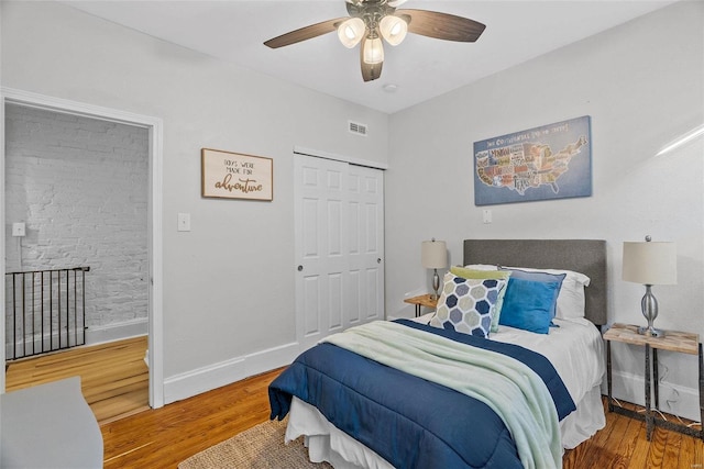 bedroom featuring visible vents, baseboards, a closet, and wood finished floors