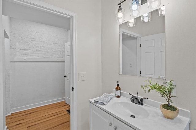 bathroom with baseboards, wood finished floors, and vanity