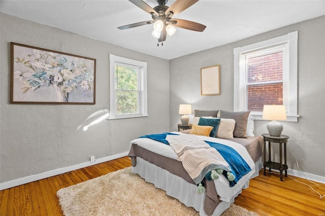 bedroom featuring a ceiling fan, wood finished floors, and baseboards