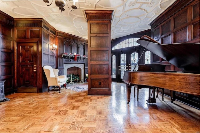 misc room with lofted ceiling, wooden walls, crown molding, and light parquet floors