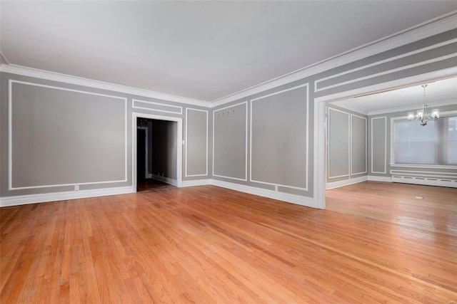 spare room with baseboard heating, ornamental molding, a chandelier, and light wood-type flooring