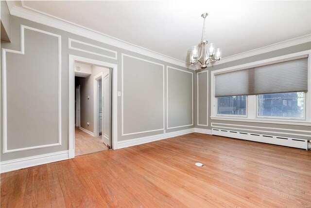 unfurnished room featuring a baseboard radiator, ornamental molding, a notable chandelier, and wood-type flooring