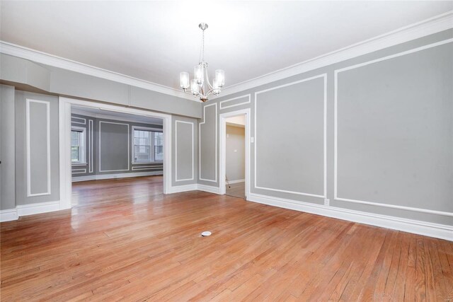 unfurnished dining area with ornamental molding, hardwood / wood-style floors, and a chandelier