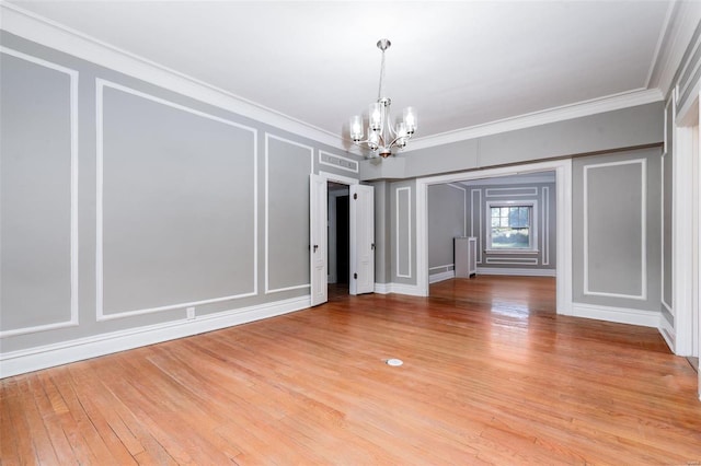 unfurnished dining area featuring crown molding, a chandelier, and light wood-type flooring