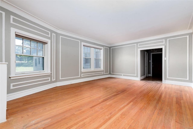 empty room with light hardwood / wood-style floors and ornamental molding