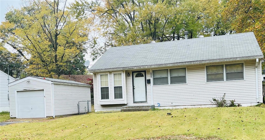 view of front of house with an outdoor structure, a garage, and a front lawn