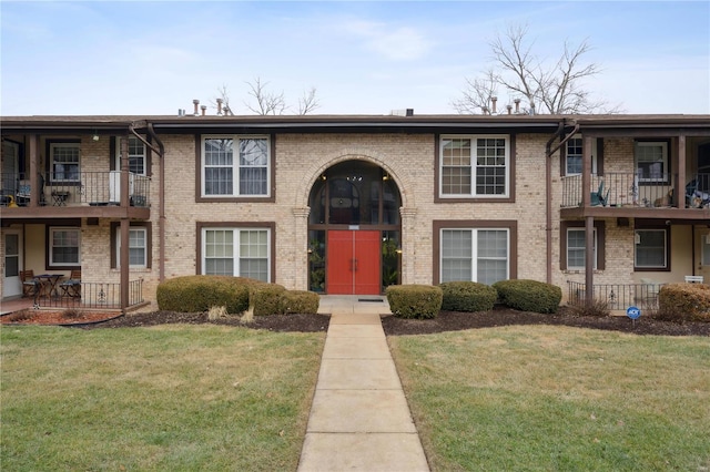 townhome / multi-family property featuring a front lawn