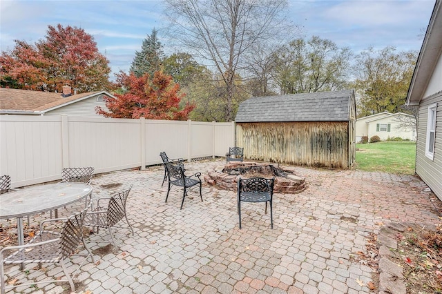 view of patio with a shed and an outdoor fire pit